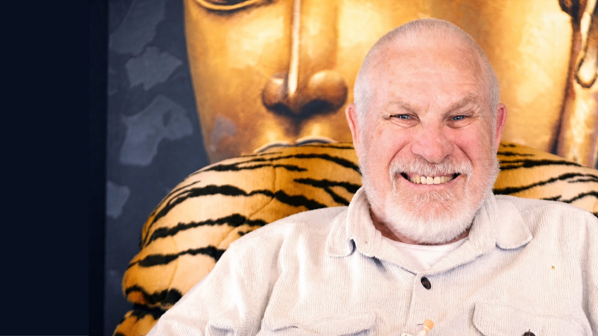 Vishrant smiling, a golden Buddha behind him.
